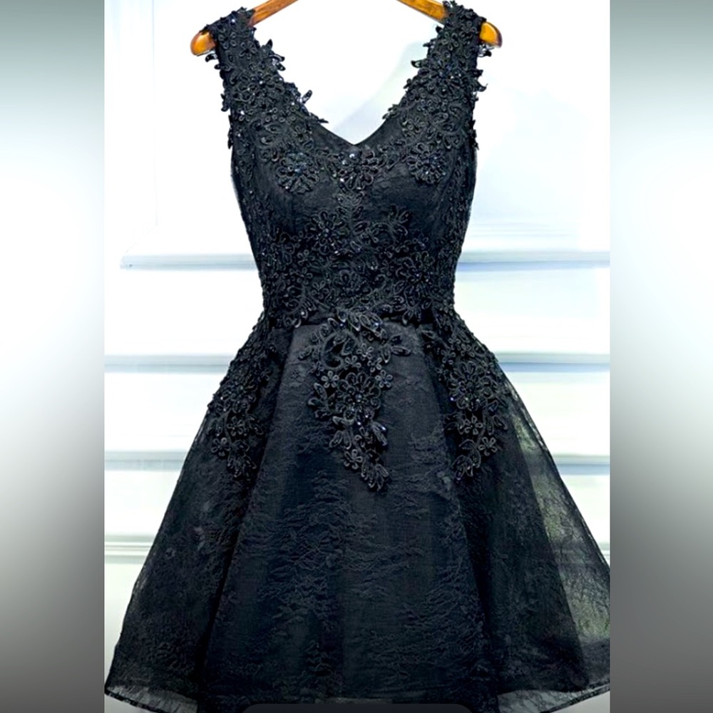 Black short style prom dress. Lace design along the top. Sheer bottom. Size 4